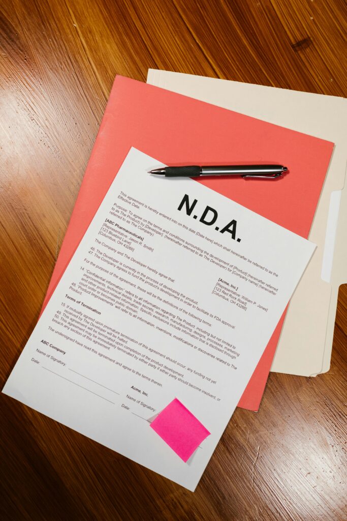 pexels-photo-7841409-7841409 Close-up of a non-disclosure agreement with a pen on a wooden table, showcasing business documentation.